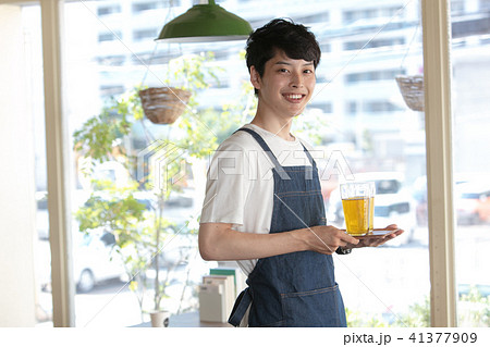 コーヒーを配膳するカフェの店員・ウェイター・オーナーの男性とテレワークする男性客の写真素材115459535- PIXTA