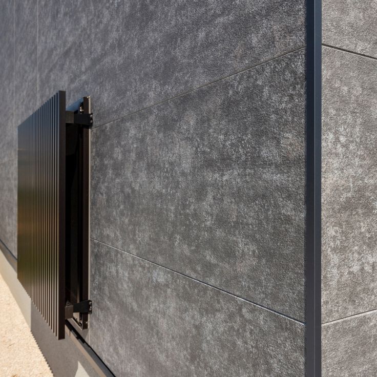 ダークコンクリートの家フィエルテの人気色、ダークコンクリートの事例をご紹介！ 縦に伸びる木目の外壁や玄関ドア、軒天がアクセントになったスタイリッシュなグレーの家 キッチンも外観と同じ木目クロスとグレーのSOLIDOで スタイリッシュにコーディネートしながら