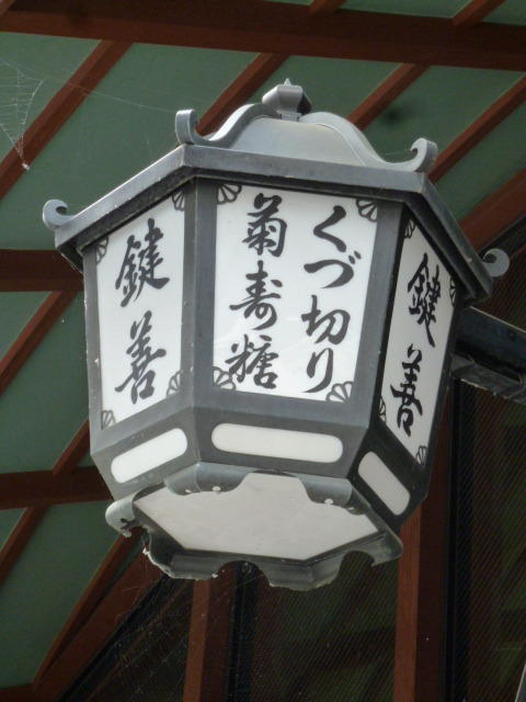 撚る屋の入り口の上には、古くからこの建物の軒にかけられていた軒灯が残っています。建物の改修に伴い、撚る屋でも使わせていただけるようデザインだけを差し替え、今もなお撚る屋の目印として灯りをともしています。Above the entrance of YORUYA is an eave lamp that