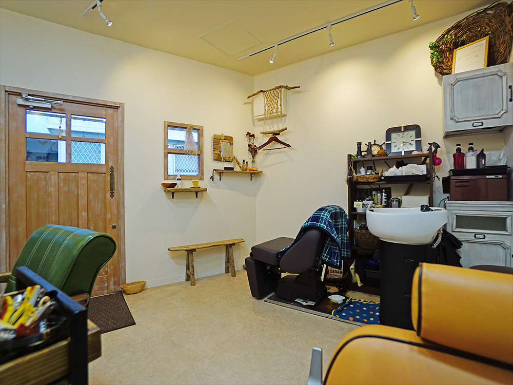 小滝健司＋高藤万葉TOAStによる、東京・港区の「窓辺の小さな美容室」。面積は小さいが大きな窓面のある区間。水平に連続する額縁に“フレームレスの鏡”を配置し、“虚像と実像”が境界なく切替わる“風景”を創出。入隅を曲面とした設計は必要座席数の確保や動線の効率化に