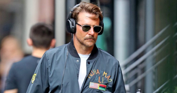 壁にもたれて音楽を聴くビジネス スーツのヘッドフォンで青年実業家Premium写真