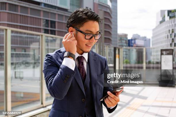 スーツを着た男性がヘッドフォンをつける。 ヘッドフォンをはいたハンサムな大人の男性」の動画素材 ロイヤリティフリー 1007208793Shutterstock