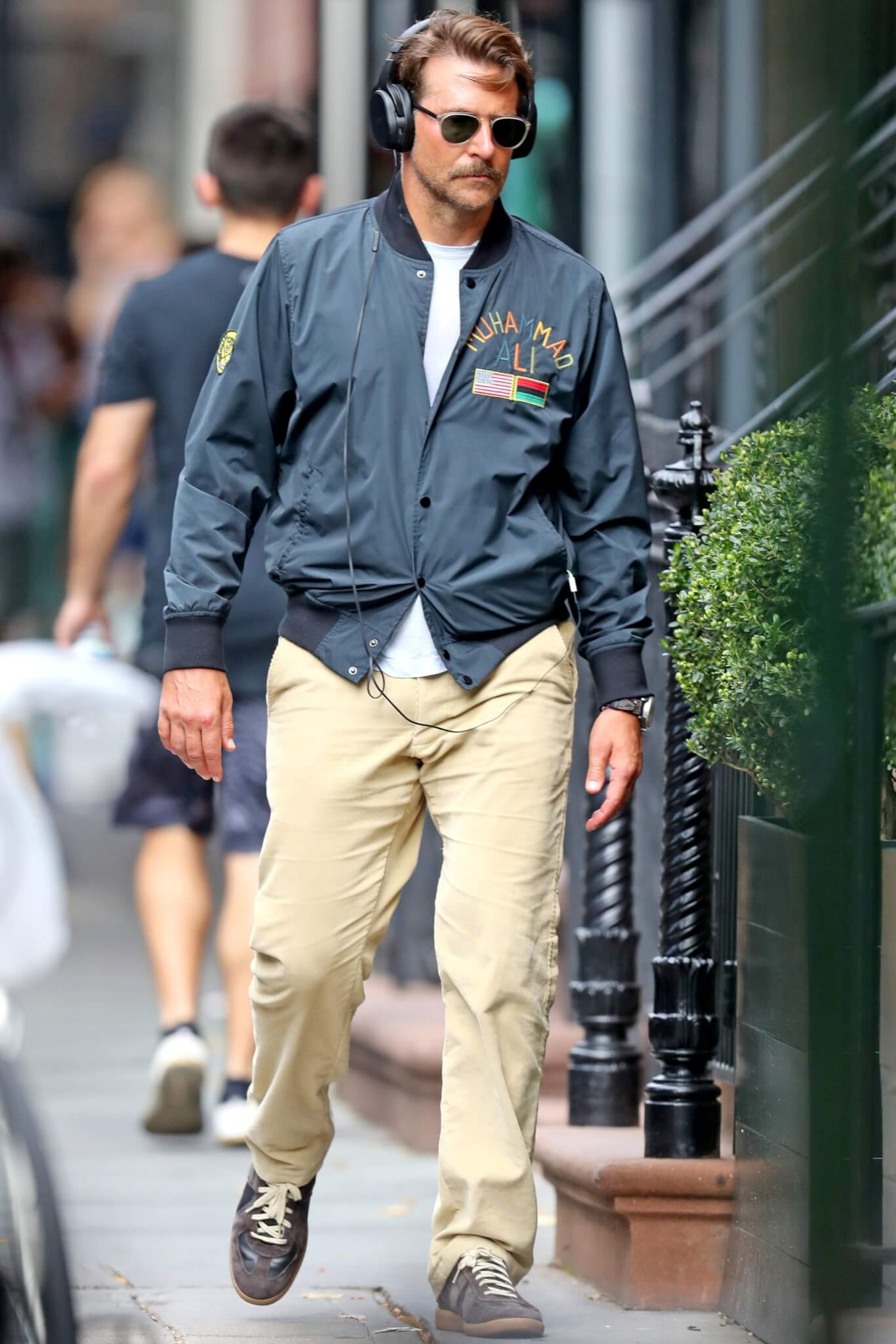 ヘッドホンをつけて踊る灰色のスーツを着た男性DJ。無料写真