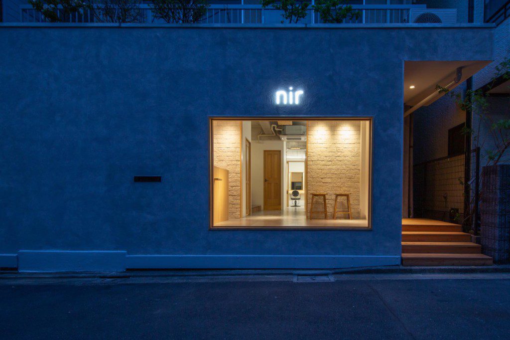 小滝健司＋高藤万葉TOAStによる、東京・港区の「窓辺の小さな美容室」。面積は小さいが大きな窓面のある区間。水平に連続する額縁に“フレームレスの鏡”を配置し、“虚像と実像”が境界なく切替わる“風景”を創出。入隅を曲面とした設計は必要座席数の確保や動線の効率化に