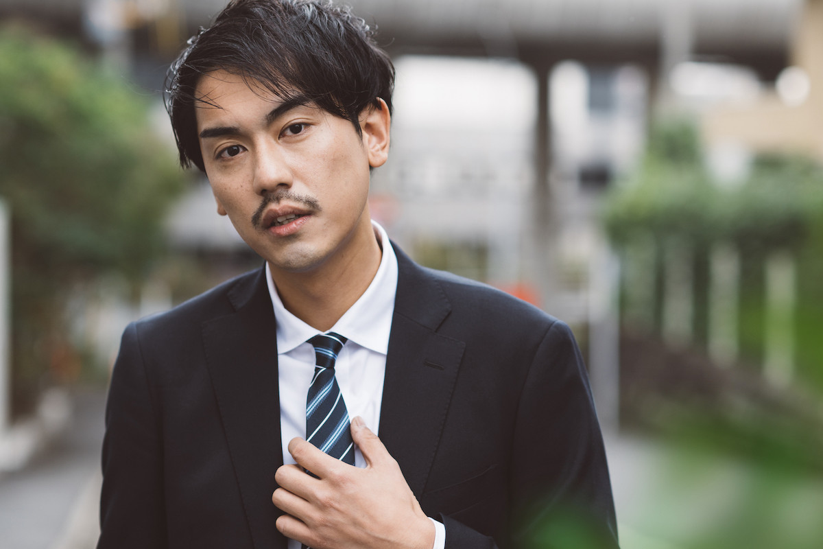 クローズアップ悩んでストレスを抱えたインドの眼鏡ひげを生やした男は、頭の高血圧頭痛の痛い頭の問題のソリューションを考える職場でノートパソコンに苦しんでいます。疲れ果てたアラビア人実業家