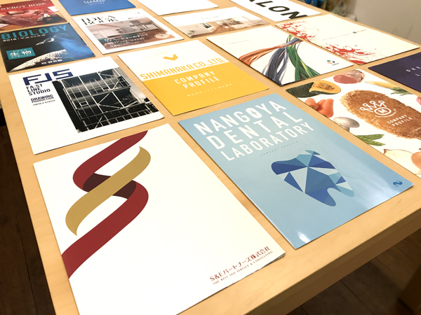 表と裏に印象的なキャッチの製品パンフレット100人のデザイナ