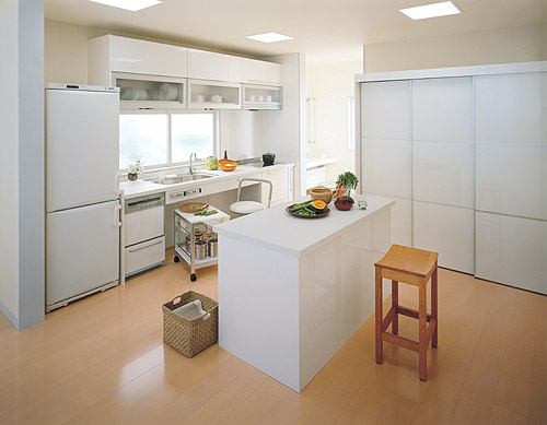 ぐるぐると回遊できる2WAYの対面キッチン。カウンターを造作し、忙しいときはここで食事をとることも。下がり天井、マガジンラックも造作 くふう